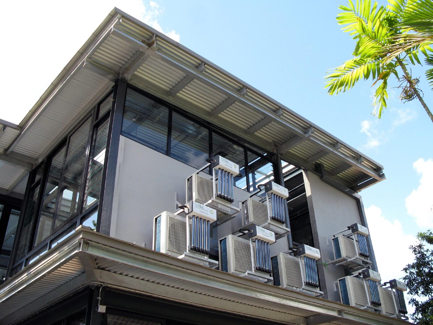 Wall-mounted condensing units with solar thermal collectors on a tropical building